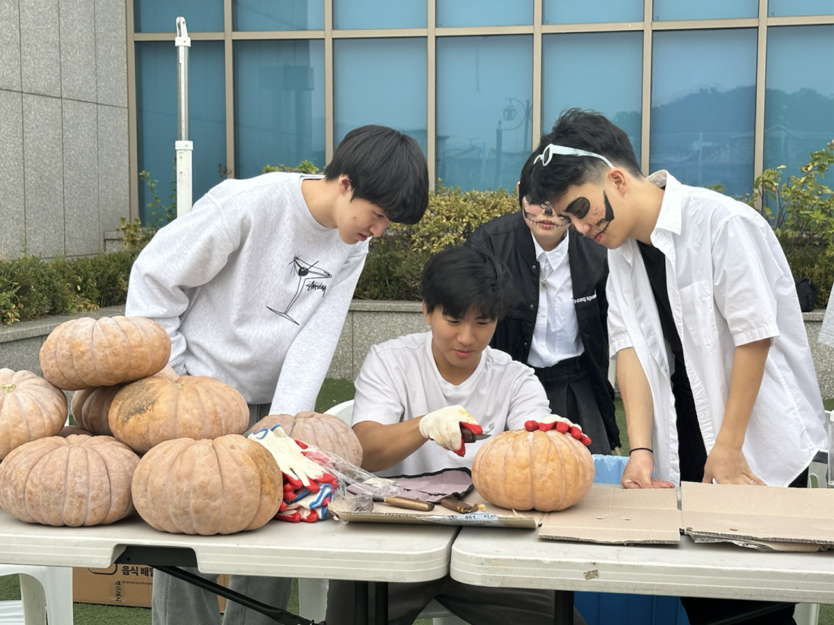 Students carving pumpkins at the Fall Festival