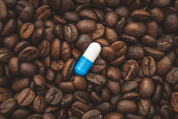 Pill on the background of coffee beans