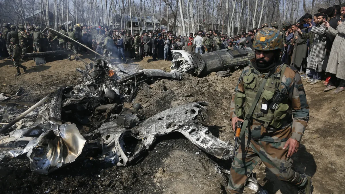 Indian soldier walks by the wreckage of an Indian aircraft on the outskirts of Srinagar, part of the Indian-territory of Kashmir