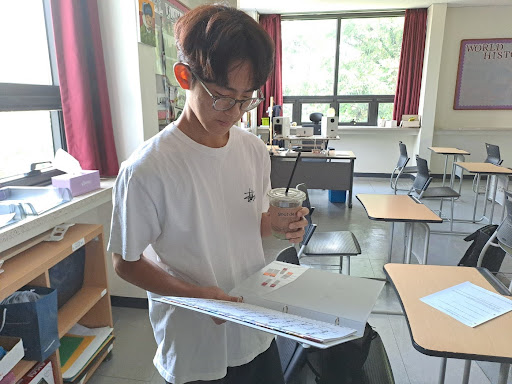 Yool Choi (12) takes a sip of his matcha latte while reviewing his formative work.