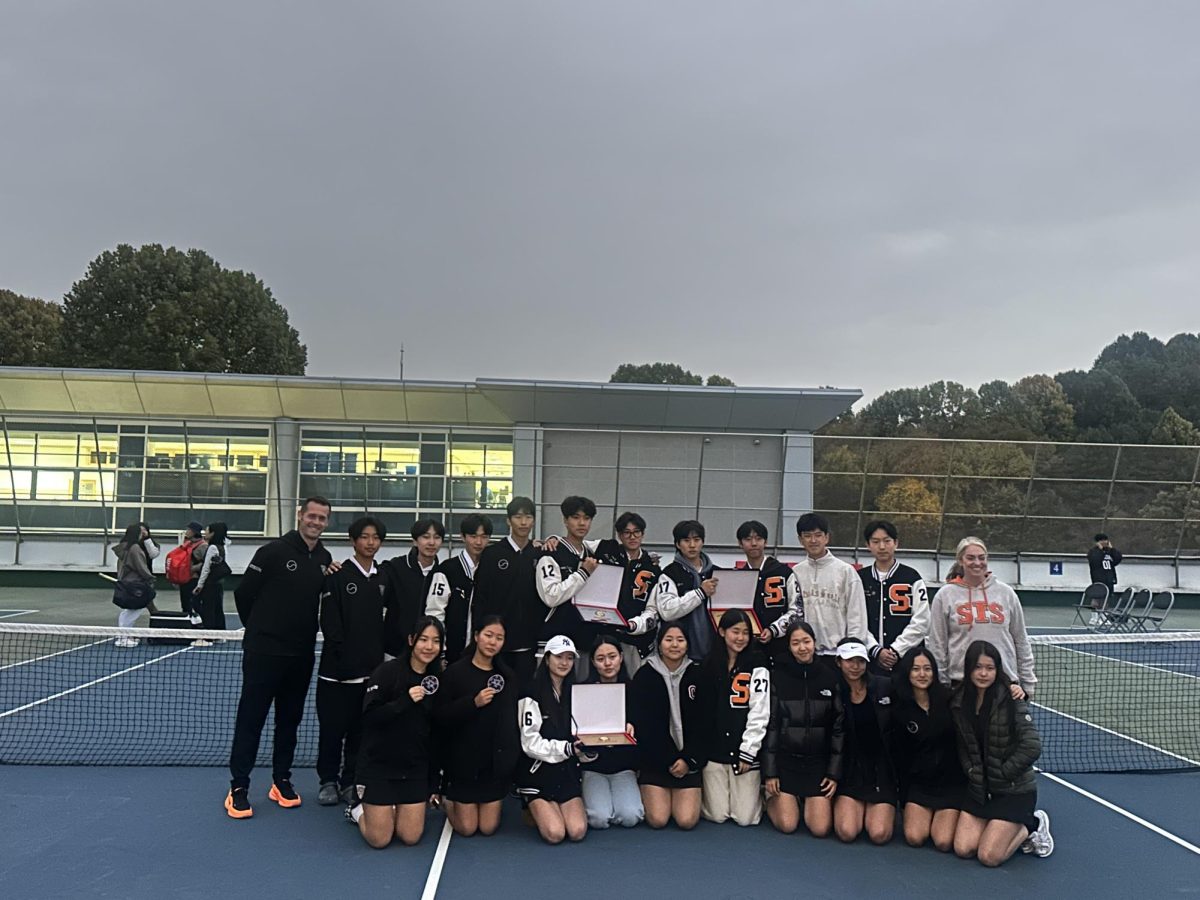 The tennis team holds their team plaques after finishing the final tournament of the year 