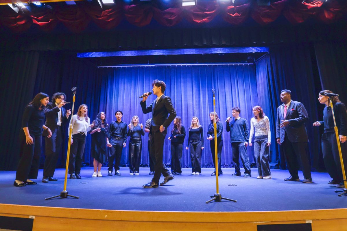 Harvard Opportunes performing in SIS auditorium on Jan. 19 during activity period. The image depicts Evan Pak (’29 graduate), singing his solo in their arrangement of "Skate" by Bruno Mars.