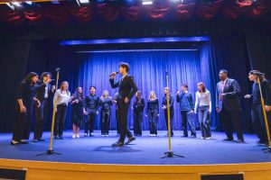 Harvard Opportunes performing in SIS auditorium on Jan. 19 during activity period. The image depicts Evan Pak (’29 graduate), singing his solo in their arrangement of "Skate" by Bruno Mars.