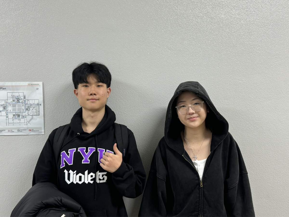Jun Lim (12) and Yena Kim (11), the varsity boys and girls basketball team managers, pose for the camera.