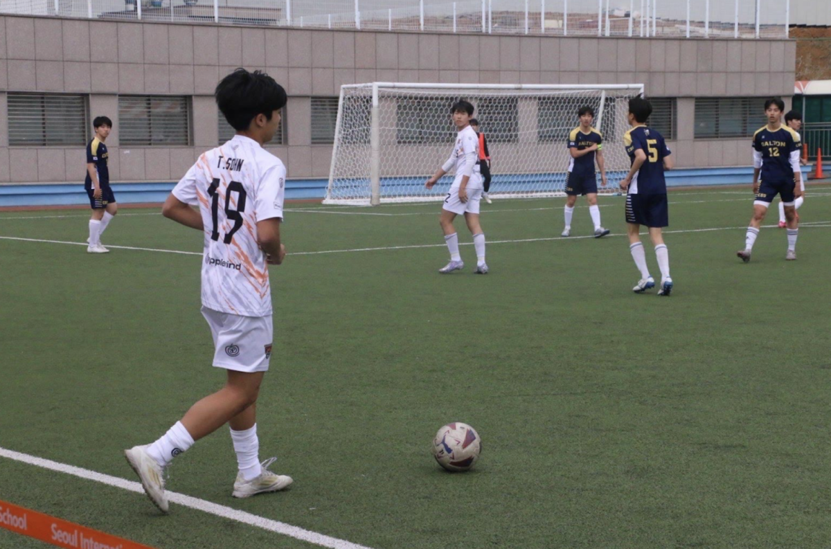 Tony Sohn (10) dribbles the ball forward during a varsity soccer game
