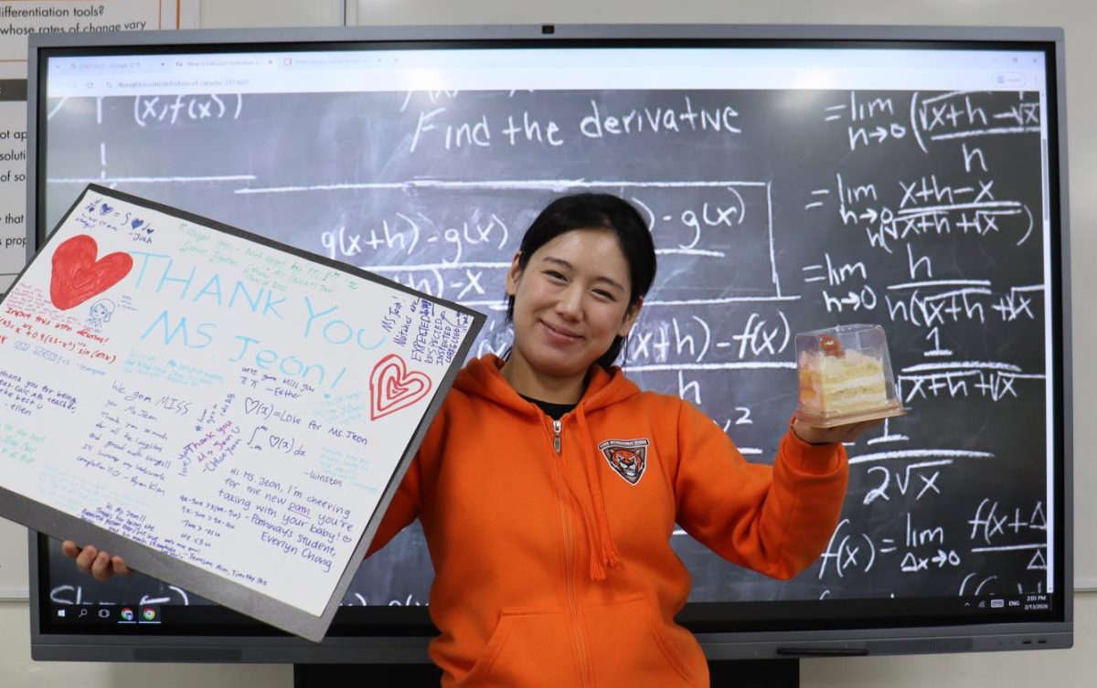 Ms. Jeon holding a Thank You poster and a present cake from students