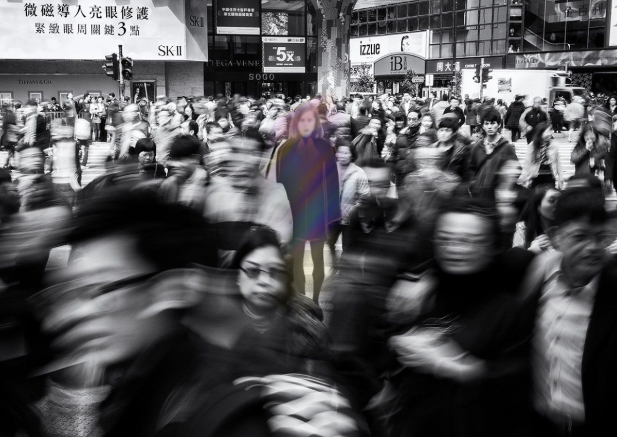 Crowd of monochrome people with one person in color 