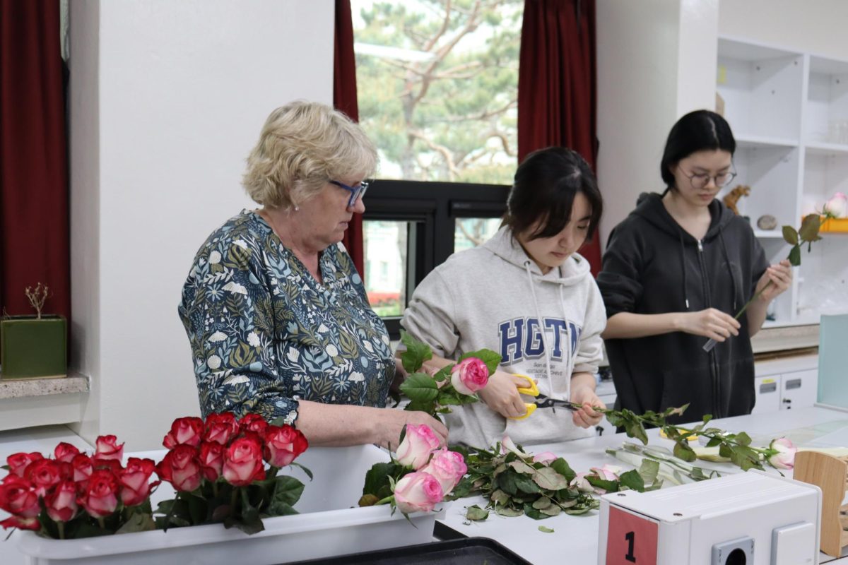Angela Campbell, Grace Ghung (11), and Heather Seo (11) arranging flowers